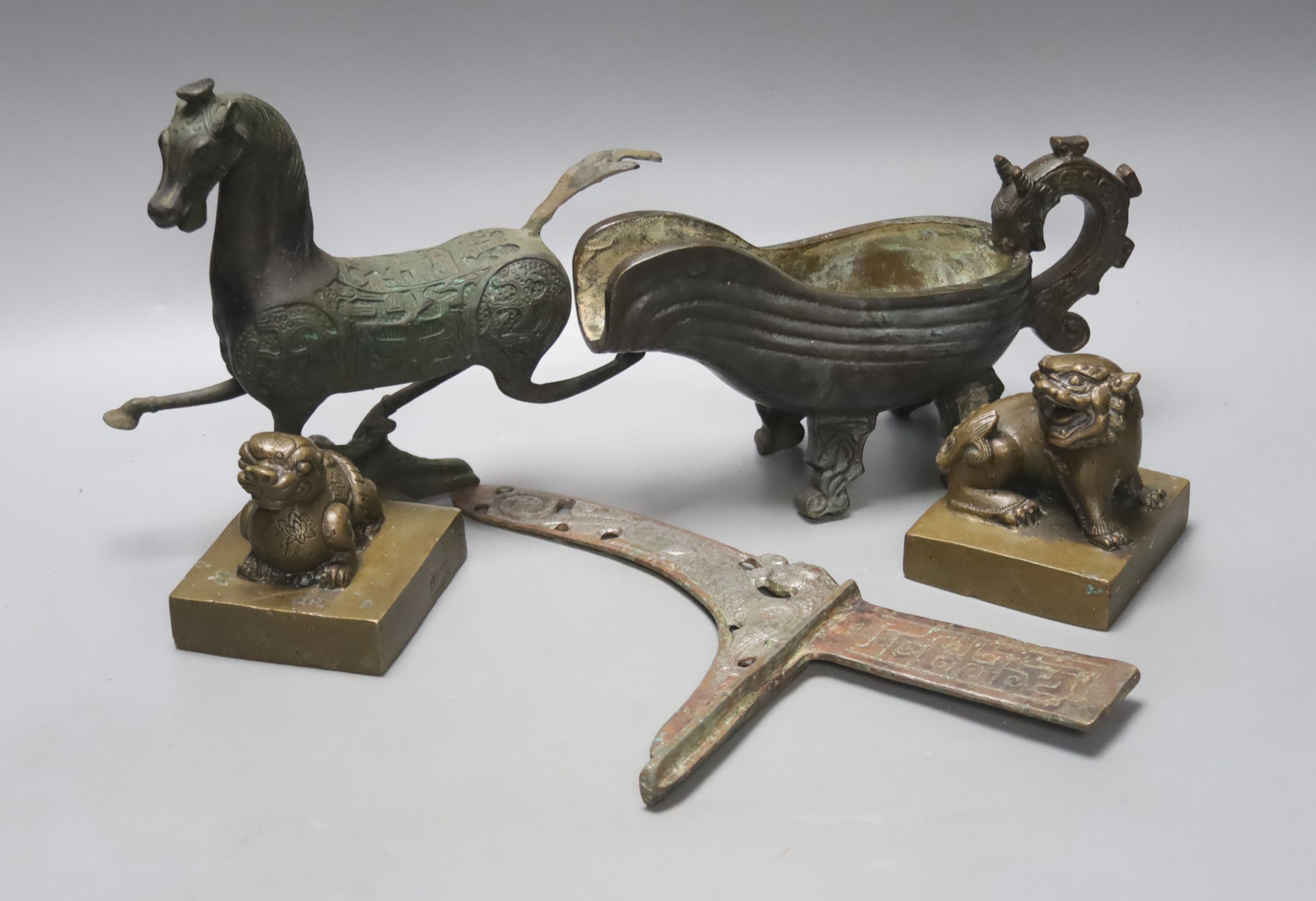 A group of Chinese archaistic bronzes, to include a pouring vessel, two ‘mythical beast seals’, a prancing horse figure and a spearhead